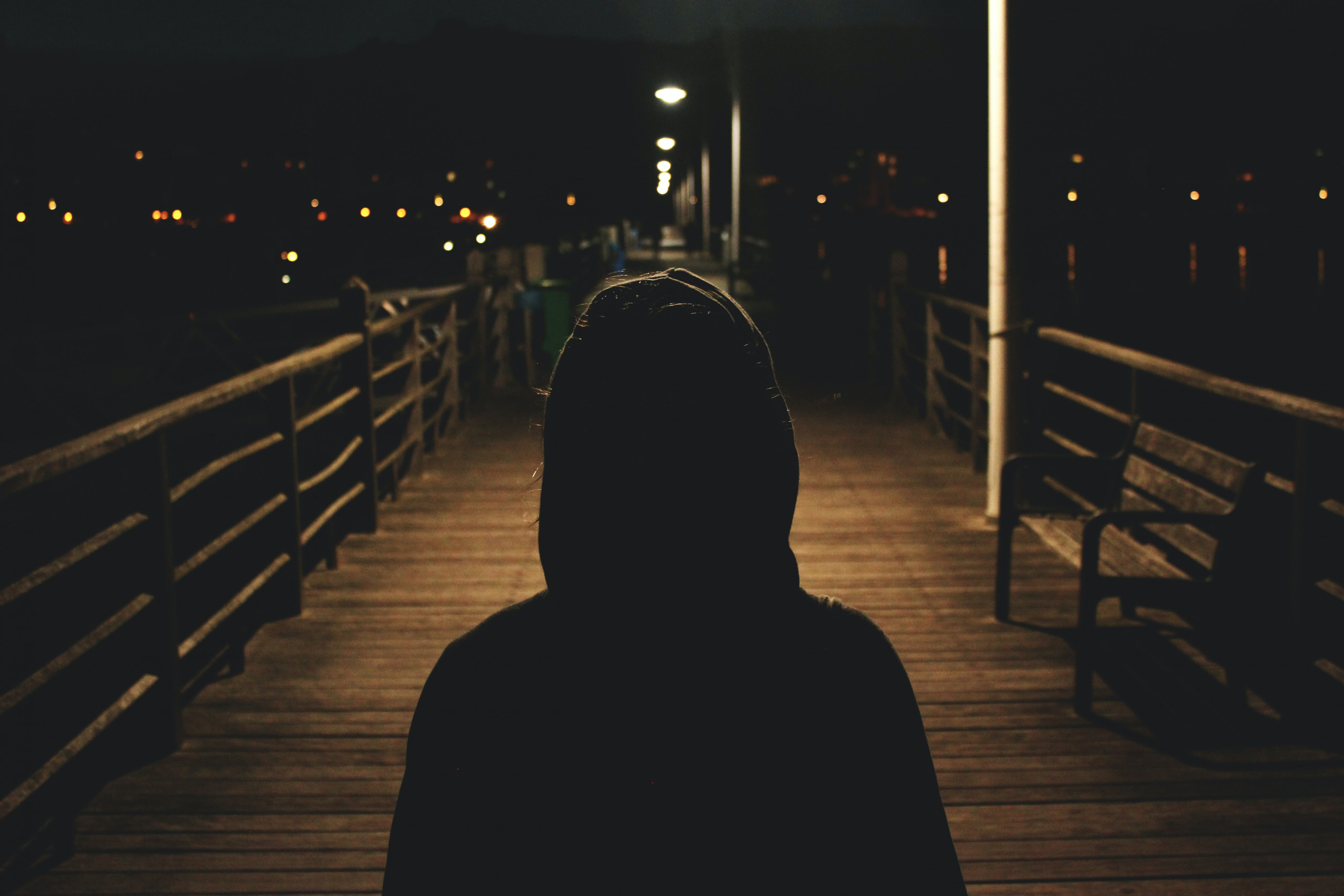 stranger danger - person wearing hooded jacket walking in bridge